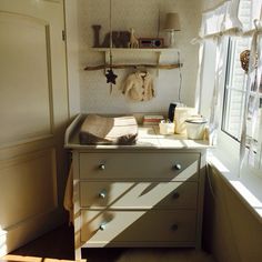 a baby's crib in the corner of a room next to a window