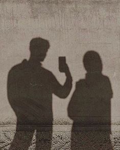 the shadow of two people standing next to each other