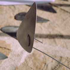 a metal object with pins sticking out of it's center on top of some rocks