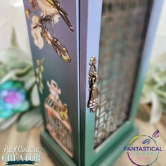 a close up of a decorative cabinet with flowers and birds painted on the front door