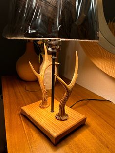 a lamp that is sitting on top of a wooden table with a glass shade over it