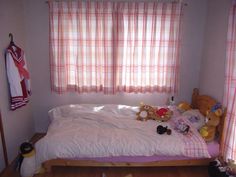 there is a bed with teddy bears on it in the room next to two windows