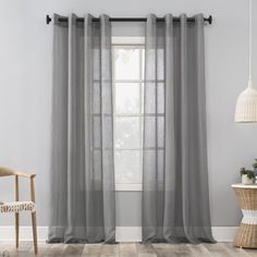 a living room with grey curtains and a chair