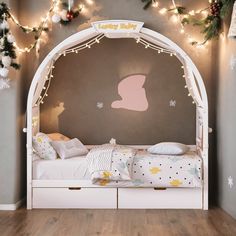 a child's bedroom decorated for christmas with lights and garlands on the wall