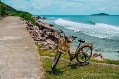 a bike parked on the side of a road next to the ocean