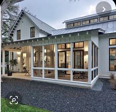 a large white house with lots of windows on it's front porch and covered patio