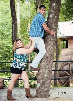 a man and woman standing on top of a tree