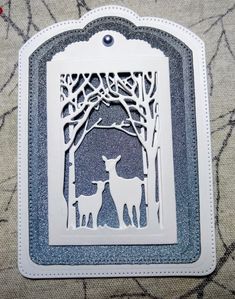 a card with an image of two deers in the woods, one is cut out from