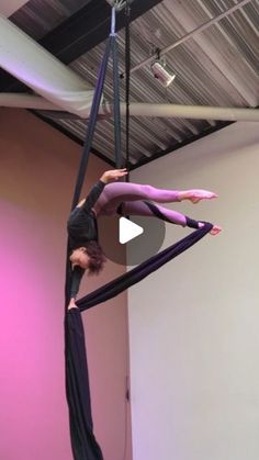 two women doing aerial acrobatic tricks in a room