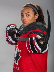 a woman holding a hockey stick in her hands