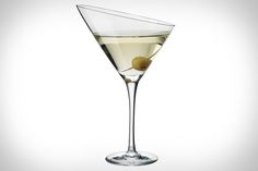 a martini glass filled with white wine and an olive garnish on the rim