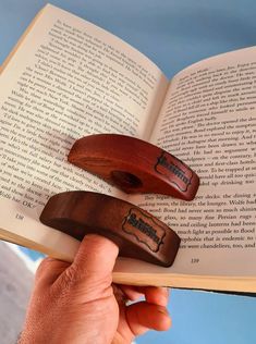 two wooden bookends sitting on top of an open book