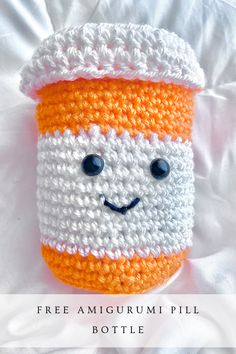 an orange and white crocheted coffee cup with a smile on it's face