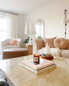 a living room filled with furniture and a book on top of a table in front of a window