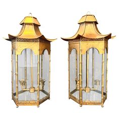 two gold colored lanterns with glass panels on each side and an animal in the middle