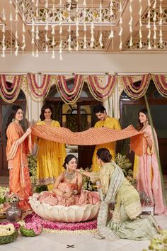 a group of women standing around each other in front of a stage with flowers on it