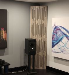 a room with speakers and paintings on the wall