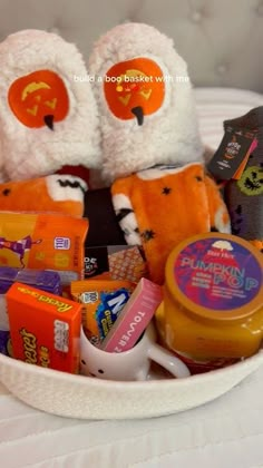 a white bowl filled with lots of candy and stuffed animals