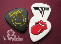 three decorated cookies with different types of guitar picks on top of each other and the words nirvana above them