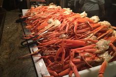 a large pile of lobsters sitting on top of a counter