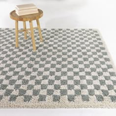 a table with a book on top of it in front of a checkered rug