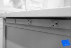 an empty dishwasher in a kitchen with blue stickers on the drawer doors