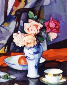 a painting of roses in a blue vase on a table next to a cup and saucer