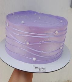 there is a purple cake with white icing on it