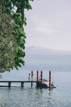 two people standing on the end of a dock