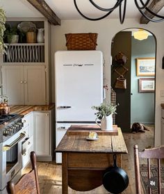 a kitchen with an old fashioned refrigerator and wooden table