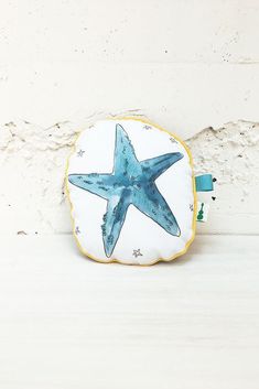 a blue starfish sitting on top of a white wall