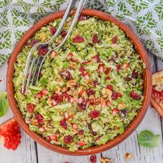 a bowl filled with broccoli salad next to some strawberries