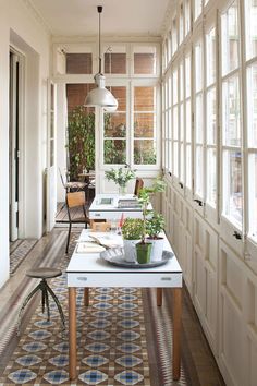 an image of a long table in the middle of a room with lots of windows