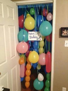 the door is decorated with balloons, streamers and other decorations for a birthday party