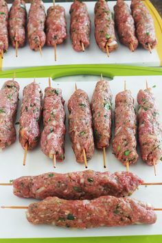 several skewered meats are being prepared on a cutting board