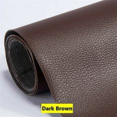 dark brown leather with yellow sticker on the bottom and black backings to it