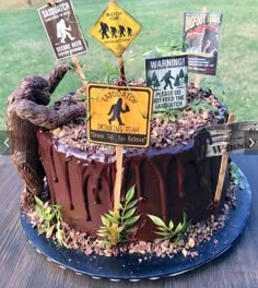 there is a cake that has various signs on the top of it and trees in the middle