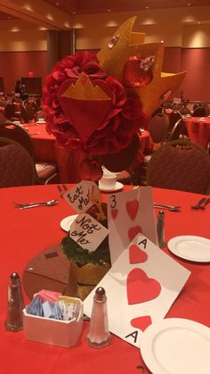 a red table topped with cards and plates