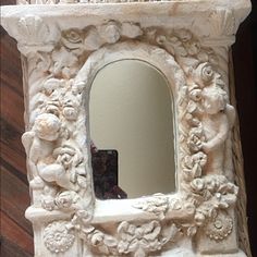 a white mirror sitting on top of a wooden table