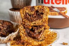 two muffins stacked on top of each other next to a container of nutella