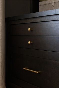 Dark cabinets with brass knobs and pulls in a moody office space. Moody Office Space, Cabinets With Brass Hardware, Clay Jar, Black Dressers, Cabinet Paint Colors