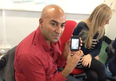 a man sitting in an office chair holding up a cell phone