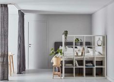 a bedroom with white walls and grey curtains