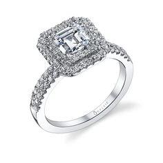 an engagement ring with a square cut diamond surrounded by pave diamonds on the band