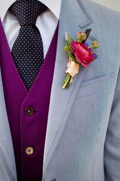 a man in a suit and tie with a boutonniere on his lapel