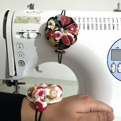 a person is using a sewing machine to sew flowers on the wristbands