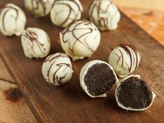 chocolate truffles with white frosting on a wooden cutting board