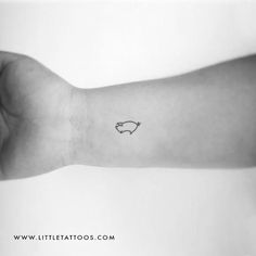 a black and white photo of a hand with a small pig tattoo on it's wrist