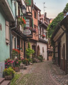 an old cobblestone street with flowers on the balconies