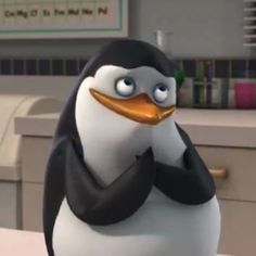 a cartoon penguin is sitting on a desk